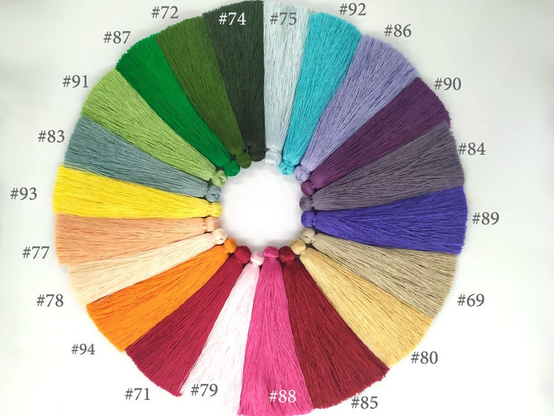 May include: A color chart of 20 different colored tassels. The tassels are arranged in a circle, with the numbers 69, 71, 72, 74, 75, 77, 78, 79, 80, 83, 84, 85, 86, 87, 88, 89, 90, 91, 92, 93, and 94 printed next to each tassel.