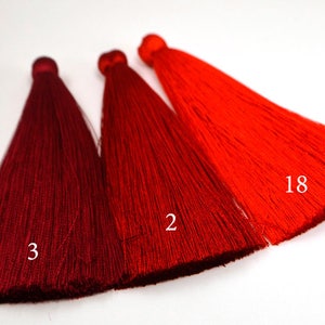May include: Three red tassels, one dark red, one medium red, and one bright red. The tassels are labeled with the numbers 3, 2, and 18.