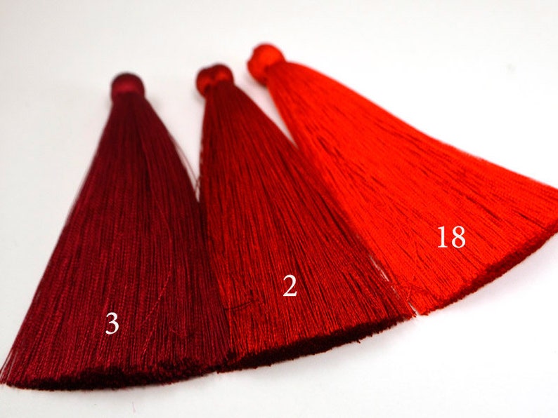 May include: Three red tassels, one dark red, one medium red, and one bright red. The tassels are labeled with the numbers 3, 2, and 18.