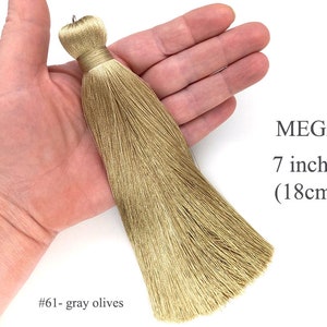 May include: A long, 7-inch (18cm) gray olive silk tassel. The tassel is held in a hand, showing its size and texture.