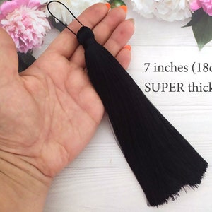 Könnte beinhalten: Ein schwarzer Quaste mit einer Länge von 18 cm. Die Quaste wird als "SUPER dick" beschrieben.
