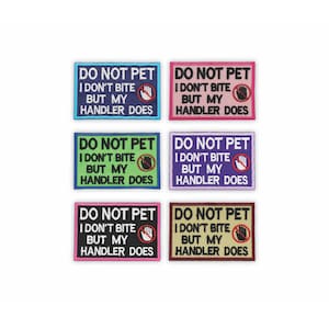 May include: Six embroidered patches with the text "DO NOT PET I DON'T BITE BUT MY HANDLER DOES". The patches are rectangular with a border and a hand symbol with a red circle and a line through it. The patches come in blue, pink, green, purple, black, and brown.