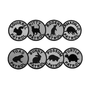 May include: Eight round, gray and black embroidered patches featuring different animals and the text "PATROL" underneath. The animals include a squirrel, kitty, rodent, armadillo, toad, bunny, possum, and turtle.