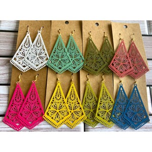 Peut inclure: Huit paires de boucles d'oreilles triangulaires en filigrane présentées sur du carton brun. Les boucles d'oreilles présentent des découpes florales complexes et sont disponibles en blanc, vert clair, vert olive, rouge, rose vif, jaune, vert lime et bleu.