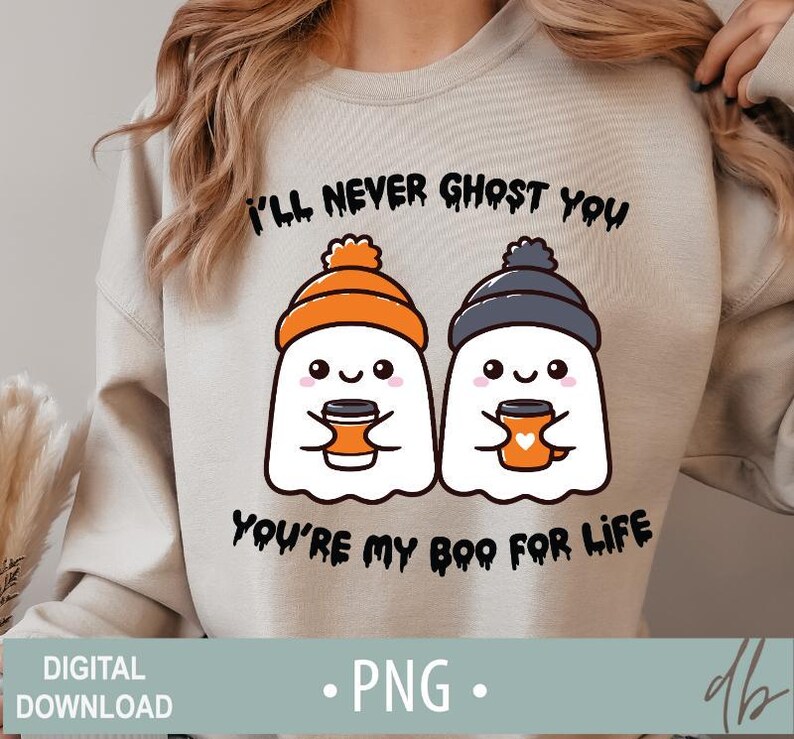 Pode incluir: Uma camisa de moletom cinza claro com um gr&aacute;fico de dois fantasmas segurando canecas de caf&eacute;. O texto "I'll never ghost you, you're my boo for life" est&aacute; impresso na camisa de moletom.