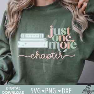 May include: An olive green sweatshirt with the text "just one more chapter" in a mix of pastel colors. The design includes a stack of books with stars. The words "DIGITAL DOWNLOAD" and "SVG PNG DXF" are also visible.