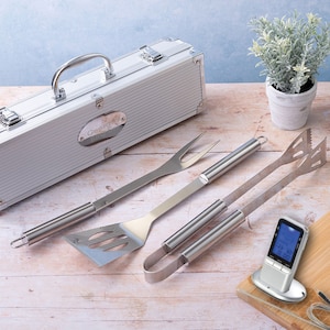 May include: A silver grilling set with a personalised carrying case, a spatula, tongs, a fork, and a digital meat thermometer.