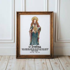 May include: A framed watercolor print of St. Dymphna, featuring a figure in a long gown, holding a book and a sword. The print includes text with a quote and the feast day. The frame is a warm brown color.