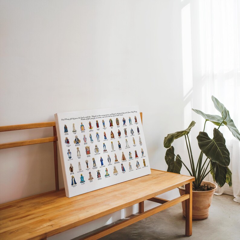 May include: A white canvas print featuring numerous illustrated figures of saints, each in colorful attire. The print is displayed on a wooden bench, with text at the top. A potted plant sits nearby, adding a touch of greenery to the scene.