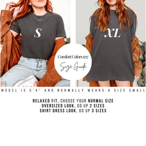 The image is a collage of two photos featuring a woman wearing a black t-shirt with a white letter "S" and an orange jacket. The collage includes text providing a size guide for the model, suggesting that the model is 5'4" and normally wears a size small. The guide advises choosing a relaxed fit, opting for an oversized look, going up to 2 sizes, and selecting a shirt dress look, with the option to go up to 3 sizes.