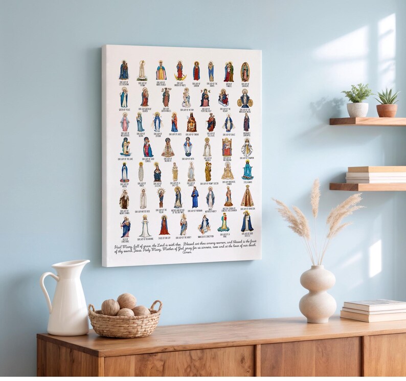 May include: A canvas print featuring numerous illustrations of the Virgin Mary in various depictions. Each image is a colorful representation of a different Marian apparition or title. The print includes text at the bottom, and is displayed on a light blue wall.