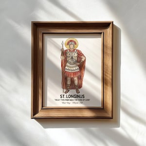 Könnte beinhalten: Ein gerahmter Druck mit St. Longinus, dargestellt in Rüstung und rotem Umhang, der einen Speer hält. Das Kunstwerk enthält den Text "ST. LONGINUS" und das Zitat "TRULY THIS MAN HAS THE SON OF GOD!" mit "Feast Day: March 15th". Der Rahmen ist aus Holz.