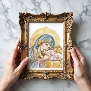 May include: A framed watercolor painting of Mary and baby Jesus. The artwork features soft colors, with Mary in a blue veil and the baby wrapped in pink. The ornate gold frame adds a classic touch to the religious art.