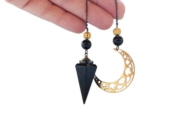 Orgonite pendulum in black and gold tones, with crescent moon and semi-precious stone called: Shungite