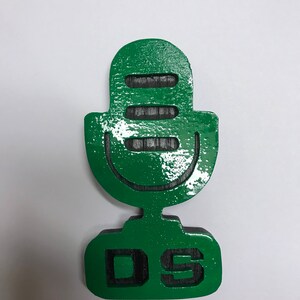 May include: Green wooden microphone with the letters "DS" on the base.
