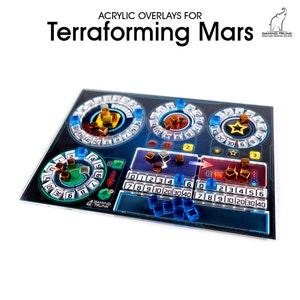 May include: Acrylic overlays for the Terraforming Mars board game. The overlays are blue and black with a futuristic design. The overlays include a star, a red arrow, and a number scale.
