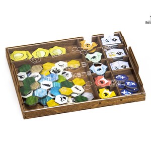 Pu&ograve; includere: Un organizzatore di gioco in legno con inserti in plastica trasparente per riporre i pezzi del gioco. L'organizzatore ha scomparti per diversi tipi di pezzi di gioco, tra cui gettoni, carte e tessere. L'organizzatore &egrave; progettato per adattarsi al gioco "Wingspan".