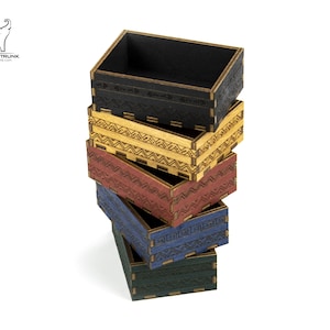 May include: A stack of six wooden boxes with different coloured stains and geometric patterns. The boxes are stacked in order from largest to smallest, with the largest box at the bottom and the smallest box at the top.