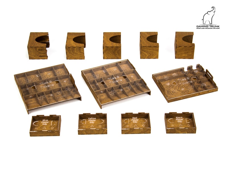 Pu&ograve; includere: Organizzatore di gioco in legno con scomparti per tessere e gettoni. L'organizzatore ha una finitura in legno marrone e include vassoi separati per ogni giocatore.