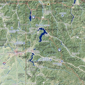 May include: A detailed topographic map of the Idaho Panhandle and surrounding areas, including parts of Washington and Montana. Features include mountain ranges, lakes, rivers, cities, and highways. Key locations like Spokane and Coeur d'Alene are labeled.