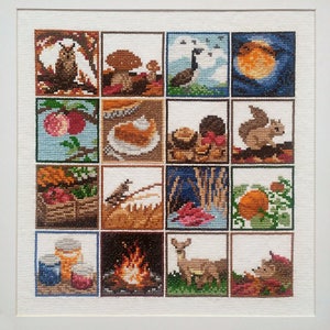 May include: A cross-stitch sampler featuring 16 autumnal scenes. The scenes include a bird, mushrooms, a goose, a full moon, apples, a pie, a squirrel, a pumpkin, a deer, a campfire, and more.