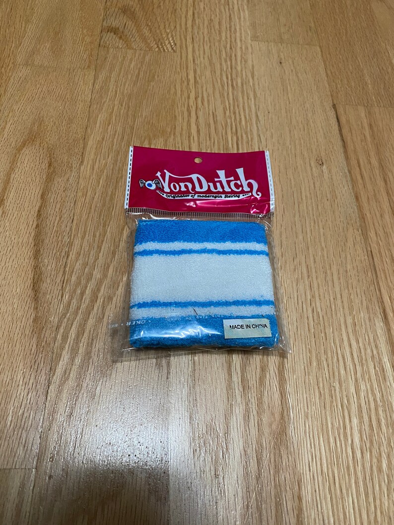 Peut inclure: Un bracelet de poignet ray&eacute; bleu et blanc avec le texte "VonDutch" sur l'emballage. Le bracelet est fabriqu&eacute; en Chine.