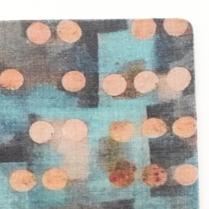 May include: A blue and brown cork coaster with a pattern of peach-colored circles.