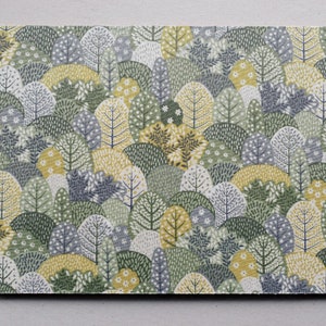 May include: Rectangular placemat with a repeating pattern of stylised trees in shades of green, yellow, and grey. The design evokes a forest scene, with various tree shapes and floral accents. The placemat has a smooth surface and a dark border.
