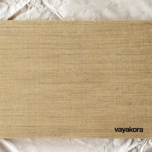 Puede incluir: Una tabla de cortar rectangular de madera con un patrón de veta de madera marrón claro. La tabla tiene la palabra "vayakora" impresa en negro en la esquina inferior derecha.