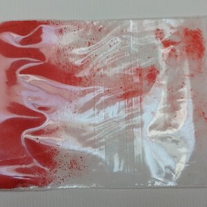 May include: A small plastic bag filled with a bright red powder. The bag is sealed with a zipper.