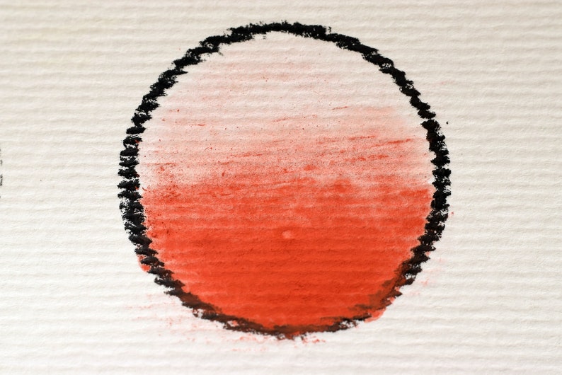 May include: A red and white ombre circle drawn in black chalk on a white textured surface.