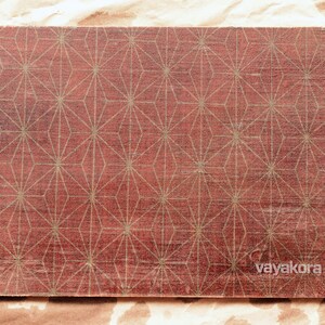 May include: A red wooden board with a geometric pattern of gold stars.