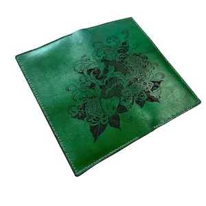 May include: A square, vibrant green leather case featuring a detailed black laser-engraved illustration of a koi fish surrounded by swirling water patterns and large chrysanthemum flowers, finished with precise stitching along the edges.