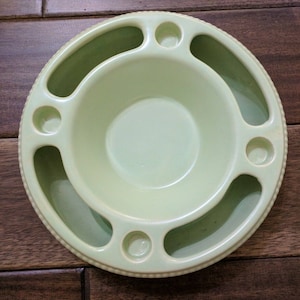 May include: A light green ceramic bowl with five indentations around the rim for candles. The bowl has a beaded edge.