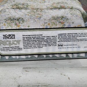 K&ouml;nnte beinhalten: Eine Packung Pequot No-Iron Percale-Bettw&auml;sche. Die Bettw&auml;sche hat ein Blumenmuster mit wei&szlig;en, blauen und gelben Blumen. Die Verpackung enth&auml;lt Text, der die Bettw&auml;sche als eine Mischung aus Polyester und Baumwolle, maschinenwaschbar und knitterarm beschreibt.