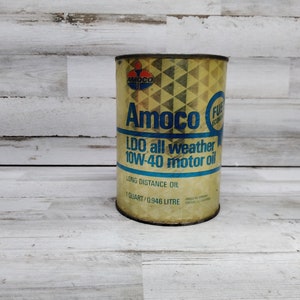 Puede incluir: Una lata de aceite vintage amarilla y azul con el texto "Amoco LDO all weather 10W-40 motor oil" y "1 quart/0.946 litre".