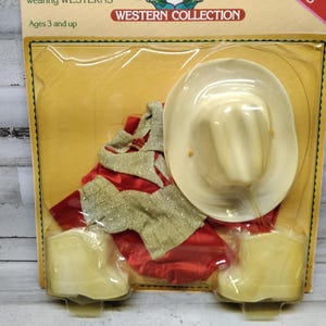 May include: A Western Collection toy set, packaged in a clear plastic blister pack. The set includes a white cowboy hat, red and silver fabric, and a pair of beige toy boots. The packaging reads "Ages 3 and up."