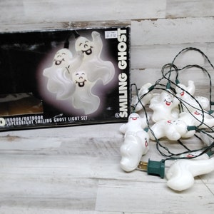 May include: A string of ten smiling ghost lights for indoor or outdoor use. The white plastic ghosts have smiling faces and are connected by a green wire. The box reads "Smiling Ghost" and "Superbright".