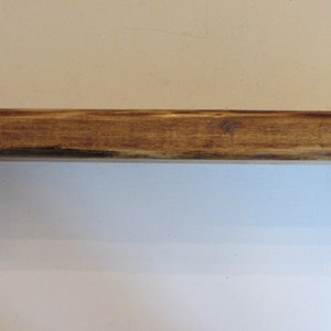 Peut inclure: Une &eacute;tag&egrave;re en bois avec des supports en m&eacute;tal noir. L'&eacute;tag&egrave;re est teint&eacute;e d'une couleur brun fonc&eacute; et a un aspect rustique.