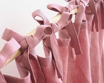 May include: Dusty rose linen curtains with tie-backs, hung on a wooden rod.