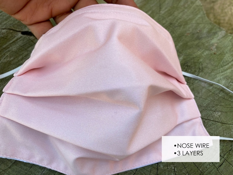 Pu&ograve; includere: Una maschera facciale rosa con un filo per il naso e tre strati. La maschera &egrave; plissettata e ha lacci elastici bianchi per le orecchie.