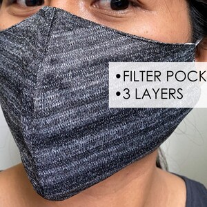 May include: A gray and black face mask with a filter pocket and 3 layers. The mask is made of a soft, breathable fabric.