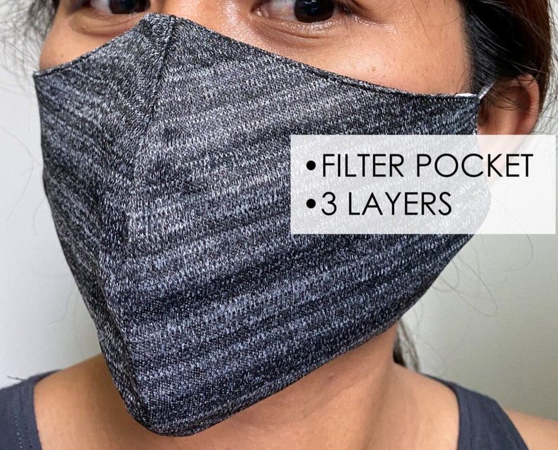 May include: A gray and black face mask with a filter pocket and 3 layers. The mask is made of a soft, breathable fabric.