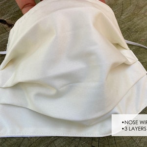 Pu&ograve; includere: Una maschera facciale bianca a tre strati e un filo per il naso. La maschera &egrave; realizzata in un tessuto morbido e liscio.