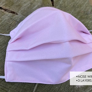 Pu&ograve; includere: Una maschera facciale rosa chiaro con un filo per il naso e tre strati. La maschera &egrave; realizzata in un tessuto morbido e traspirante e ha anelli elastici per le orecchie.
