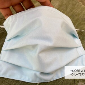 Pu&ograve; includere: Maschera facciale blu chiaro a tre strati e con un filo per il naso. La maschera &egrave; plissettata e ha lacci elastici bianchi per le orecchie.
