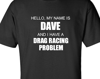 May include: Black t-shirt with white text that reads: "HELLO, MY NAME IS DAVE AND I HAVE A DRAG RACING PROBLEM." The shirt is a short-sleeved crew neck.