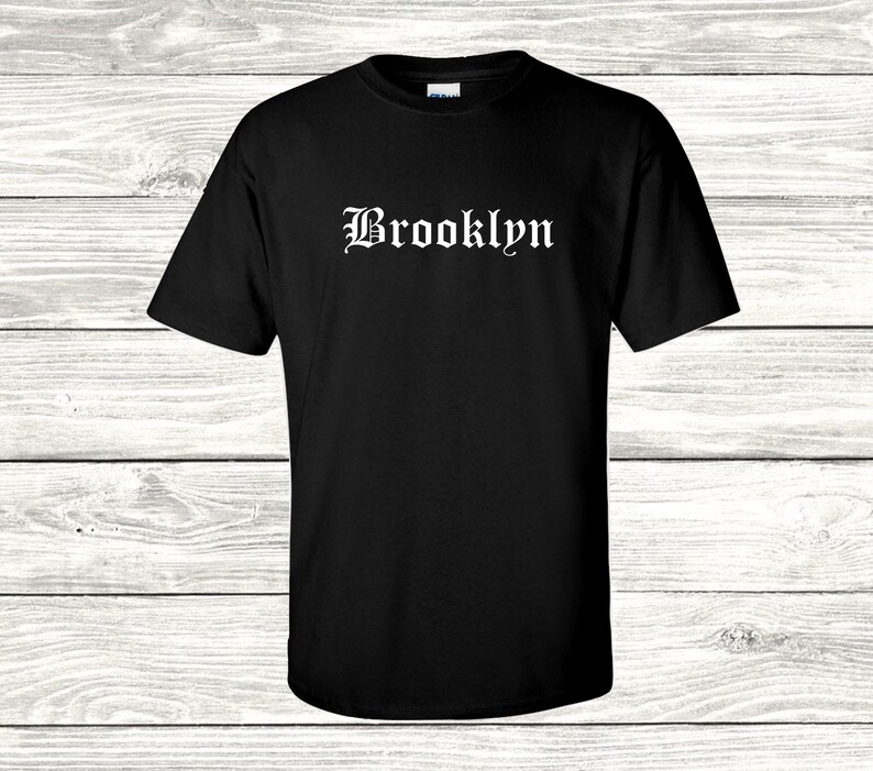Puede incluir: Camiseta negra con texto blanco que dice "Brooklyn" en una fuente g&oacute;tica.
