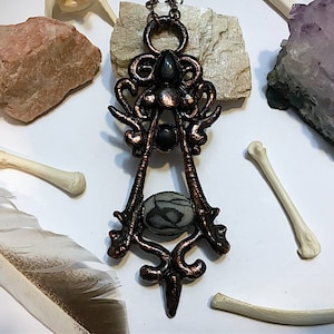 Copper skunk ulna bone replica, spiderweb jasper, and obsidian pendant necklace