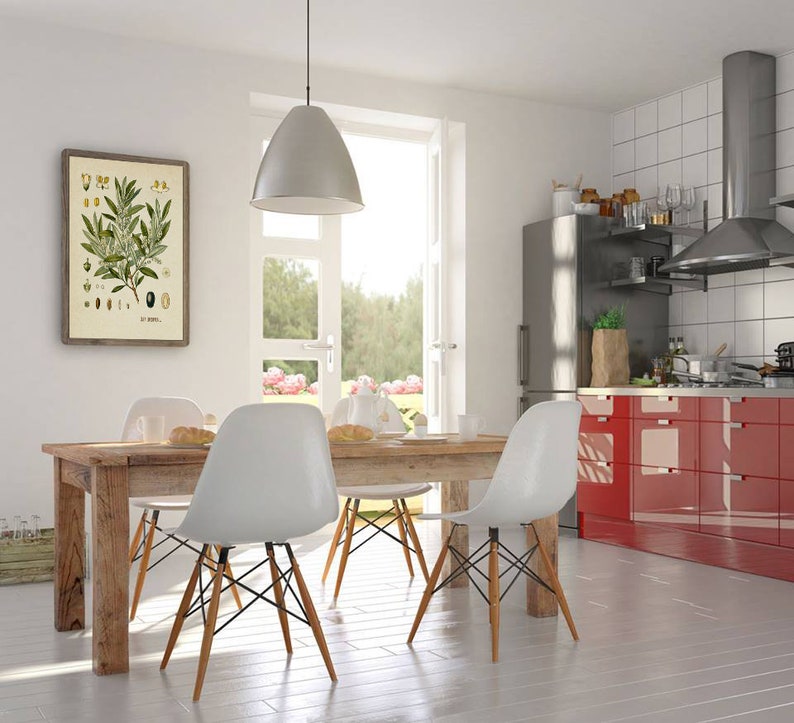 Peut inclure: Une cuisine blanche avec des armoires rouges, un r&eacute;frig&eacute;rateur en acier inoxydable et une table &agrave; manger en bois avec quatre chaises blanches. Une estampe botanique encadr&eacute;e d'une branche d'olivier est accroch&eacute;e au mur.